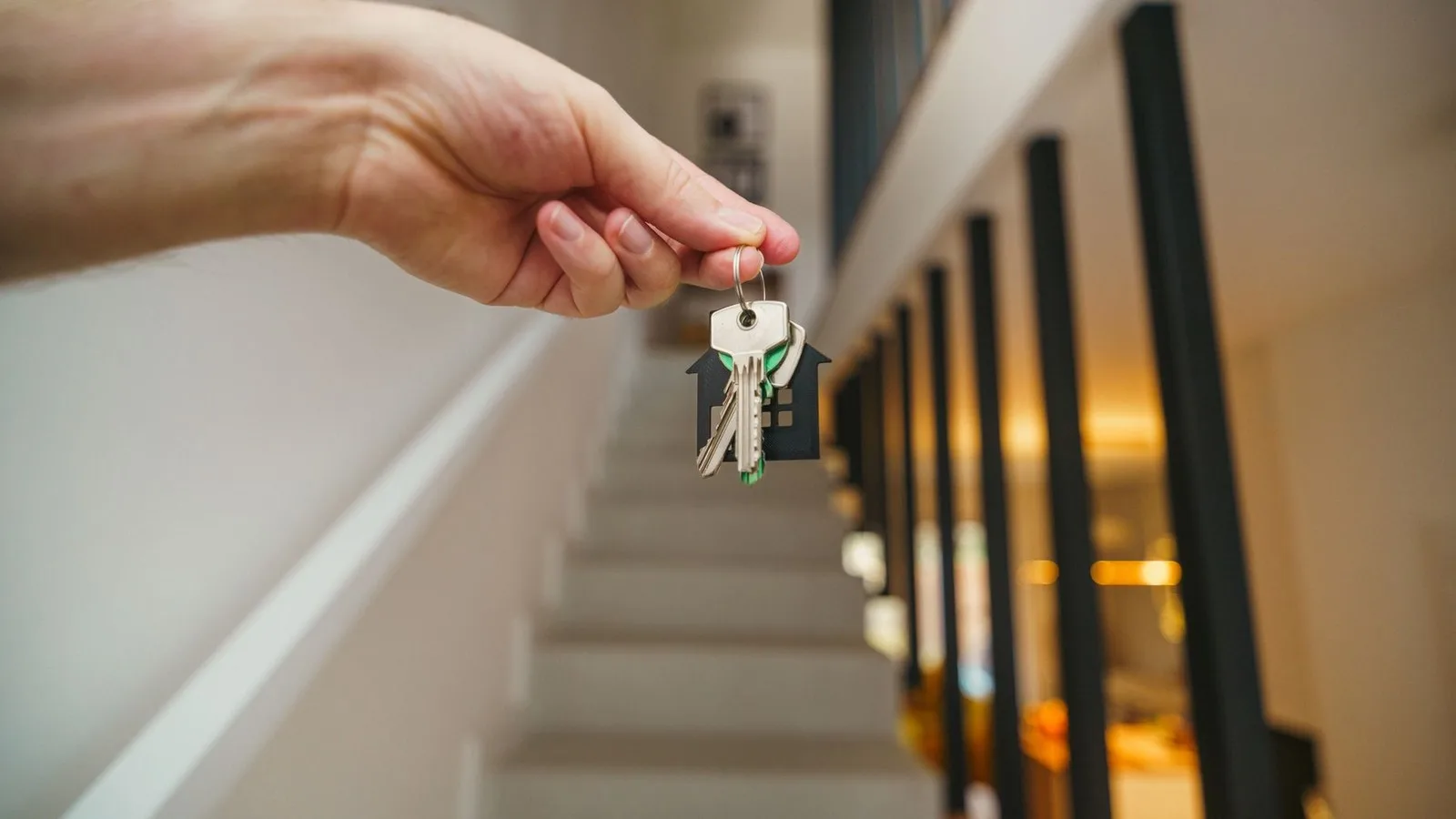 Selge hus med megler, nøkler og salgsdokumenter
